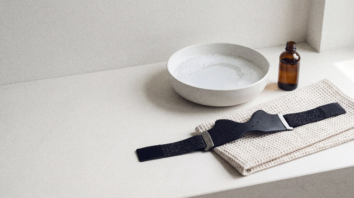 The strap air-drying flat on a towel next to a basin of soapy water