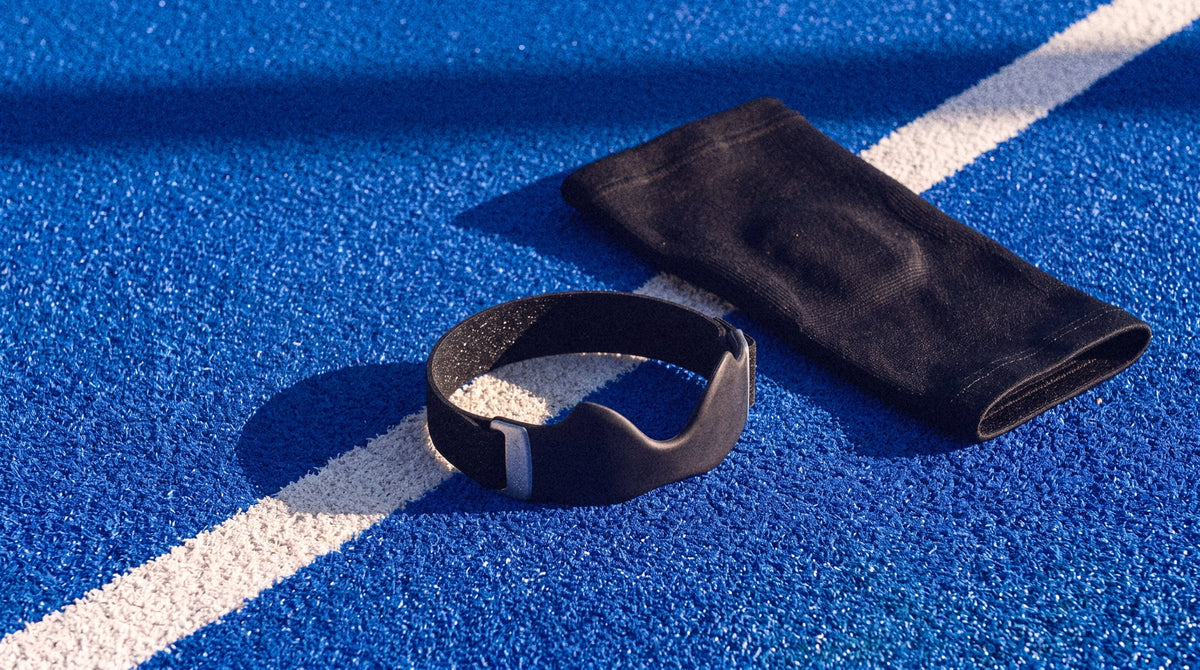 A patellar strap next to a knee sleeve on a court line